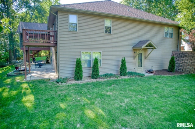 rear view of house with a wooden deck, a yard, and a patio