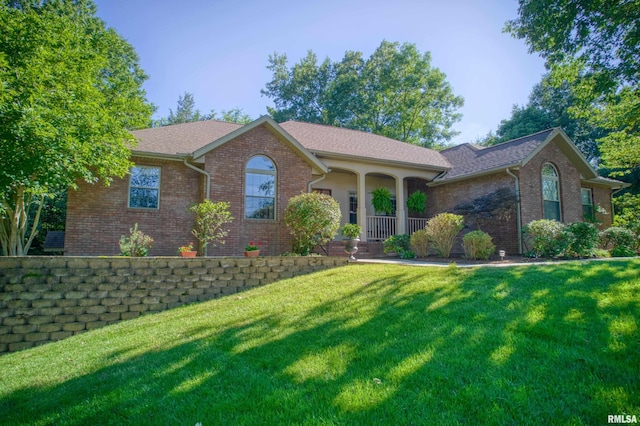 ranch-style home with covered porch and a front yard