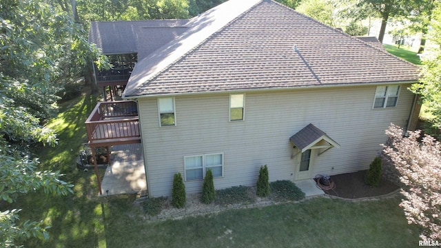 view of side of property with a deck and a yard