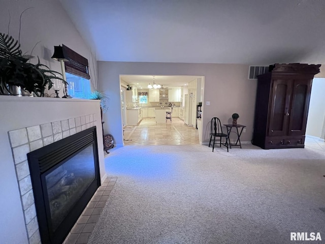 living room with light carpet, a chandelier, a fireplace, and lofted ceiling