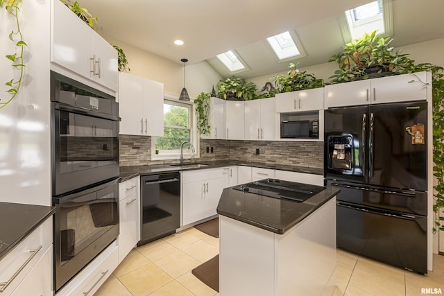 kitchen with a skylight, white cabinetry, sink, light tile patterned flooring, and black appliances