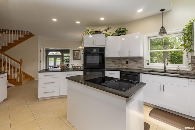 kitchen with sink, hanging light fixtures, a kitchen island, white cabinets, and black appliances