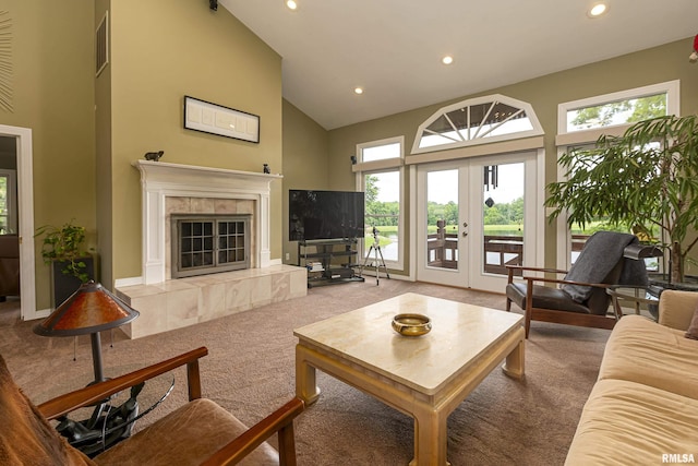 living room featuring a tile fireplace, carpet, high vaulted ceiling, and french doors