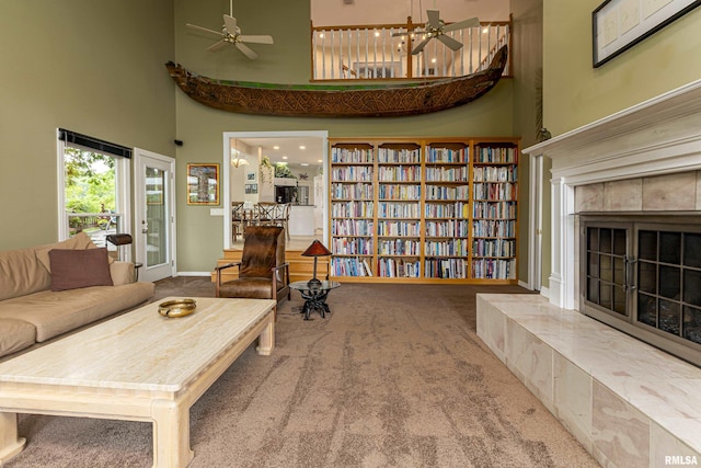 living room featuring carpet flooring, a towering ceiling, and ceiling fan