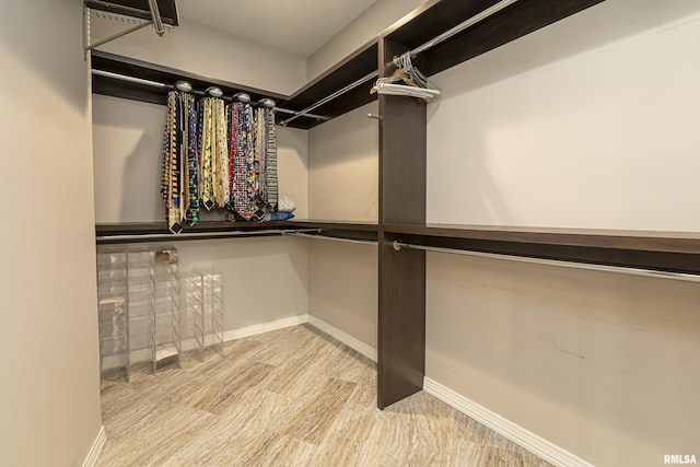 walk in closet with light hardwood / wood-style flooring