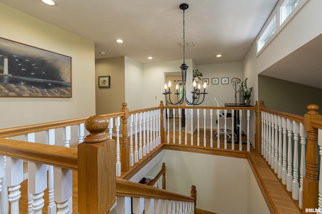 staircase with an inviting chandelier