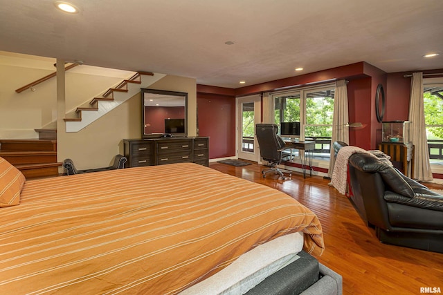 bedroom with access to exterior and hardwood / wood-style floors