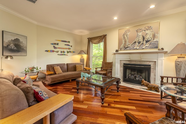 living room with a fireplace, wood-type flooring, and ornamental molding