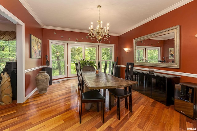 dining space with crown molding, a chandelier, and light hardwood / wood-style floors