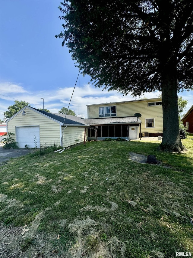 view of front of house featuring a garage, aphalt driveway, a front yard, and an outbuilding