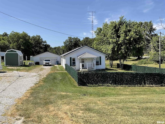 view of front of home with a storage shed, a garage, and a front yard