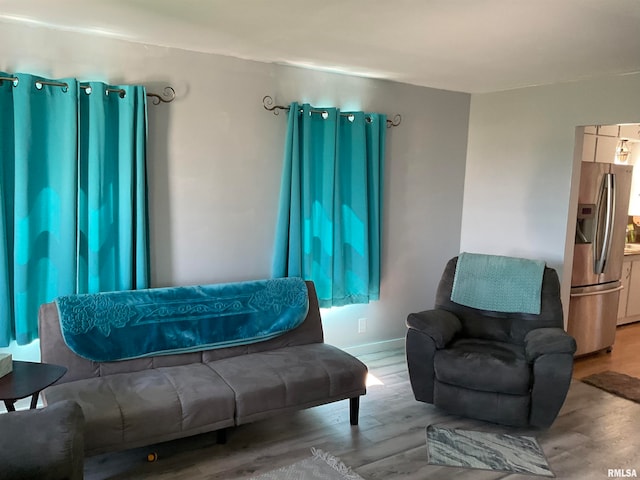 bedroom with stainless steel fridge with ice dispenser and hardwood / wood-style floors