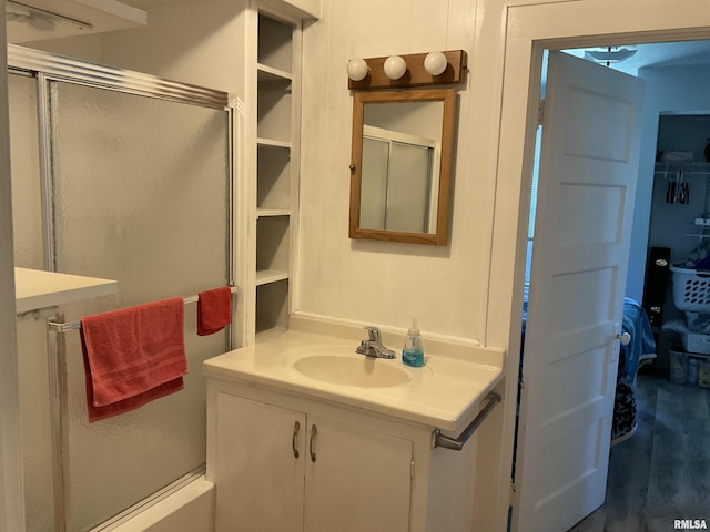 bathroom featuring vanity and a shower with door