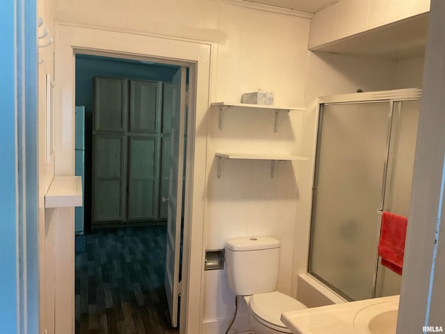 bathroom featuring combined bath / shower with glass door, hardwood / wood-style flooring, and toilet