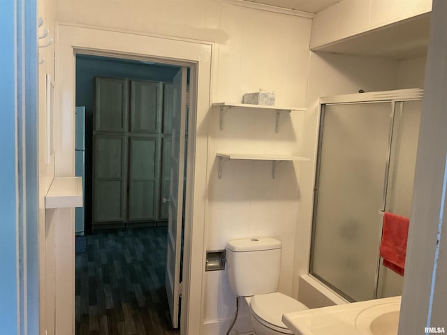 bathroom featuring wood-type flooring, toilet, and a shower with door