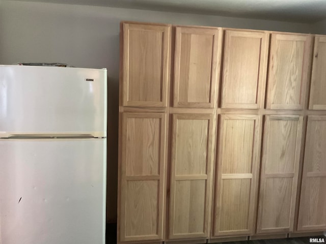 interior space with white refrigerator and light brown cabinetry