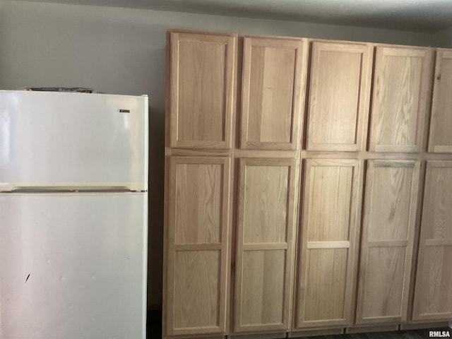 kitchen with white refrigerator and light brown cabinetry