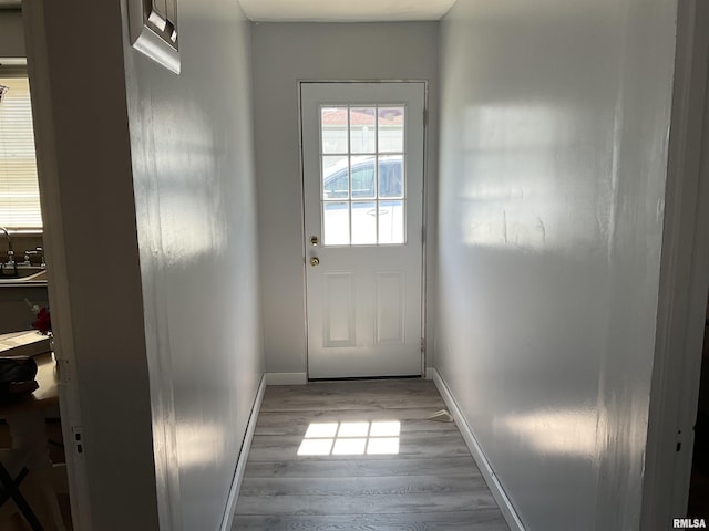 entryway with sink and light hardwood / wood-style flooring