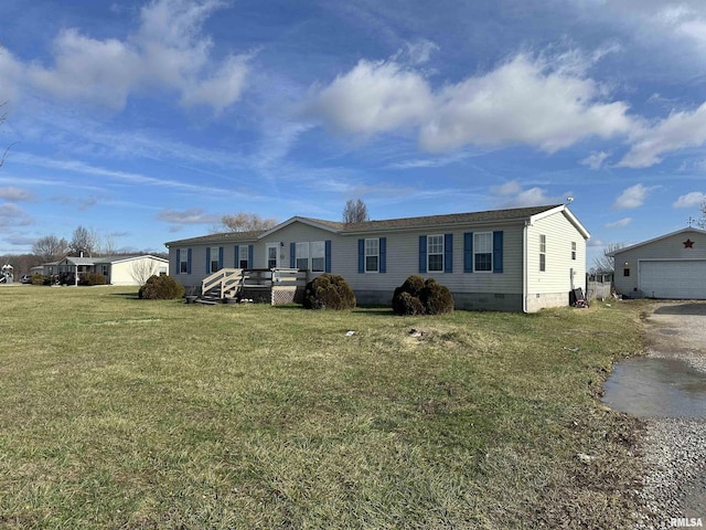 view of front of property featuring a garage, an outbuilding, a wooden deck, and a front lawn