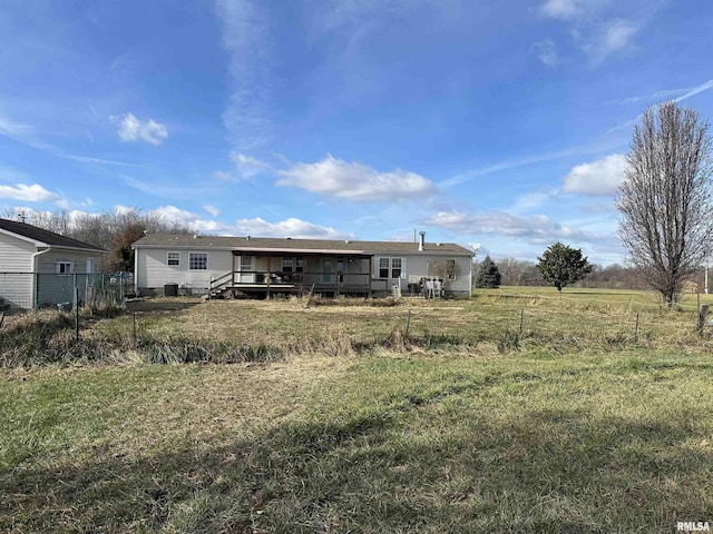 back of house with a yard, a rural view, and a wooden deck