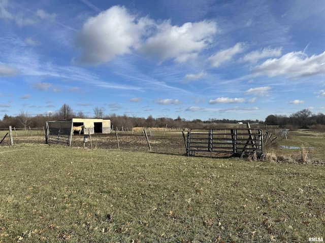 view of yard featuring an outbuilding, a pole building, a rural view, and fence