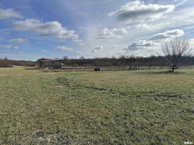 view of yard featuring a rural view and fence