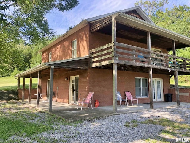 rear view of property featuring a patio and a deck