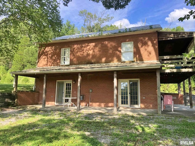 rear view of house with a lawn and a patio area