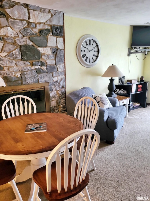 carpeted dining space featuring a fireplace