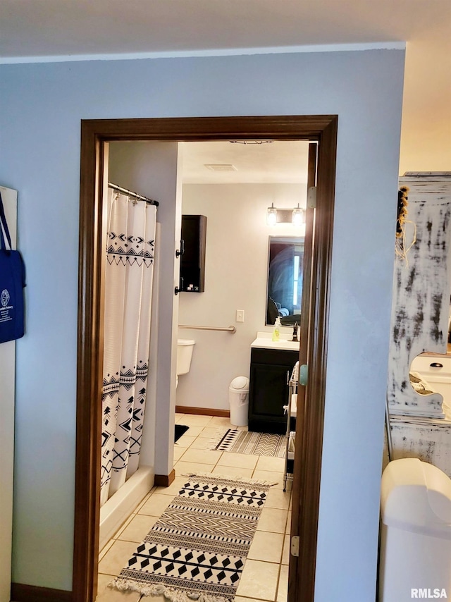 bathroom with tile patterned flooring, vanity, toilet, and curtained shower