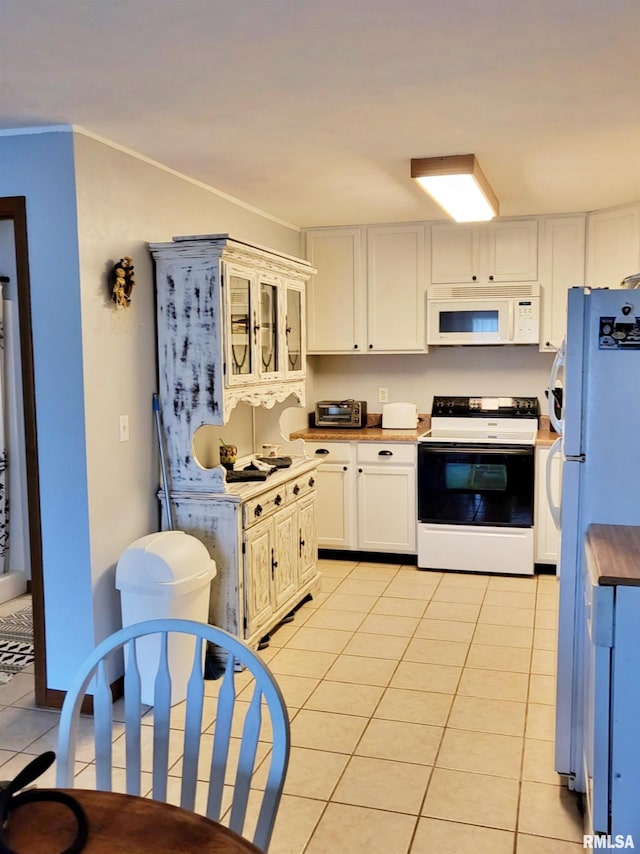 kitchen featuring crown molding, light tile patterned floors, white cabinets, and white appliances