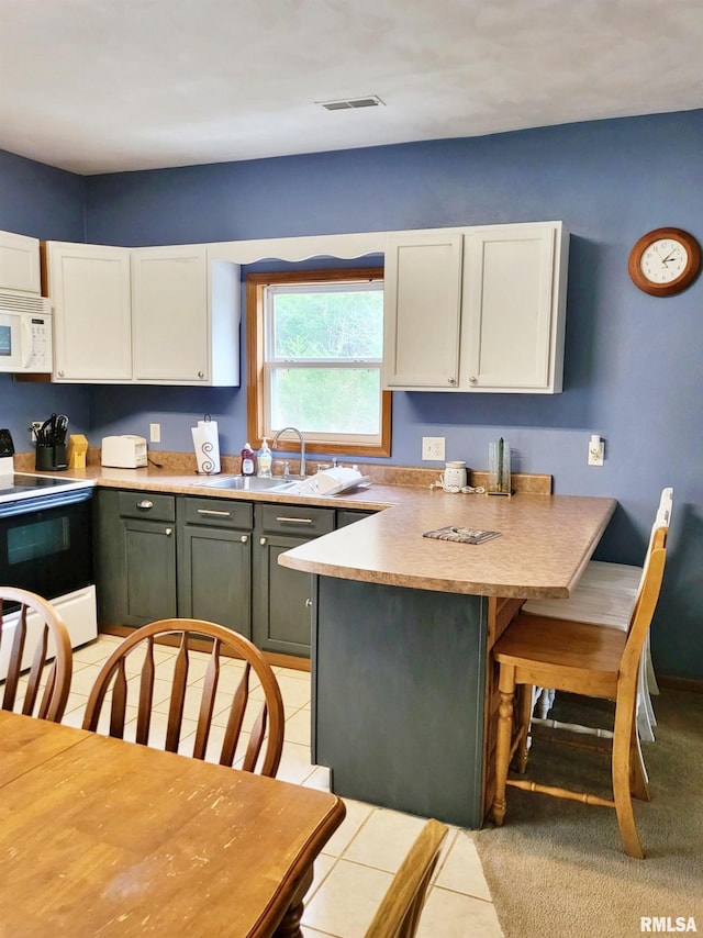 kitchen featuring sink, white cabinets, light tile patterned flooring, and white appliances