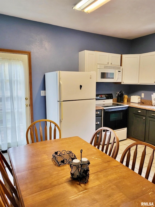 kitchen with light tile patterned floors, white appliances, and white cabinetry