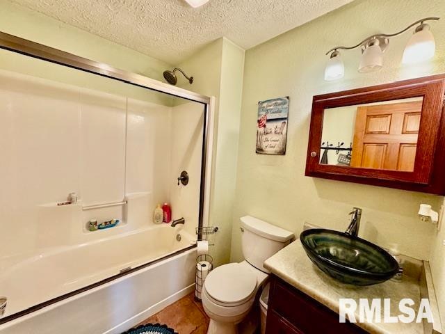 full bathroom with enclosed tub / shower combo, a textured ceiling, tile patterned floors, toilet, and vanity