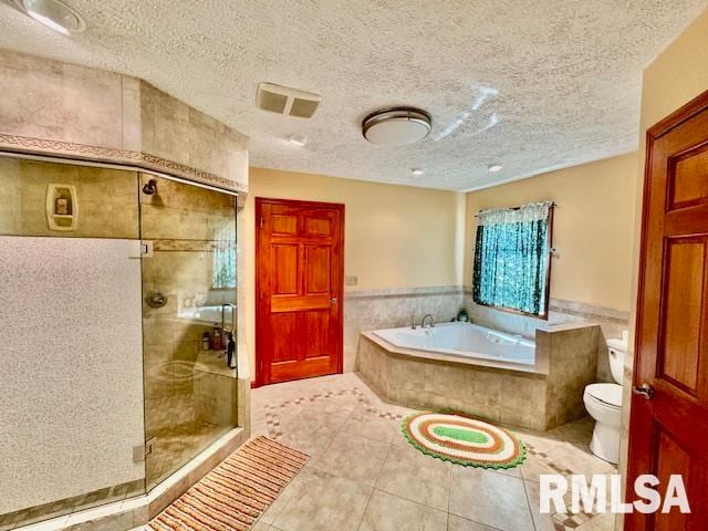 bathroom featuring plus walk in shower, a textured ceiling, toilet, and tile patterned flooring