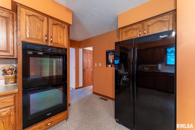 kitchen featuring a textured ceiling, light colored carpet, and black appliances