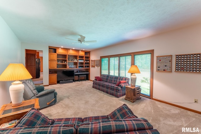 living room with a textured ceiling, carpet floors, and ceiling fan