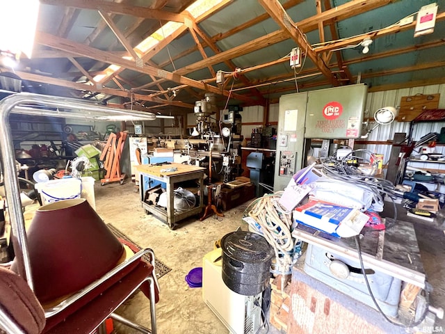 miscellaneous room featuring a garage, a workshop area, and unfinished concrete floors