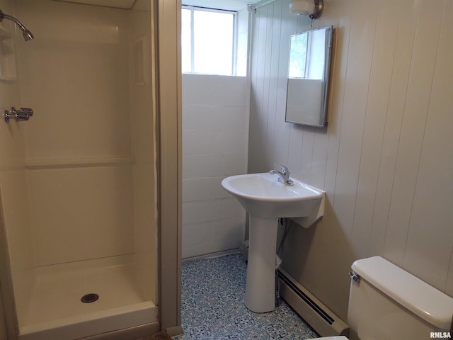 bathroom with walk in shower, wood walls, toilet, and a baseboard heating unit