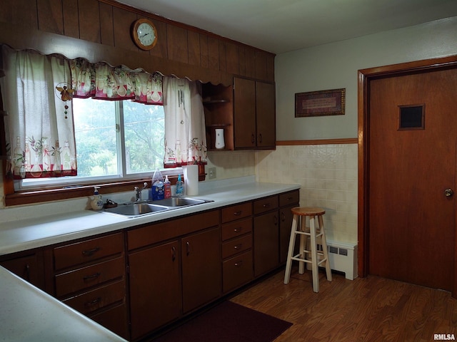 kitchen with dark brown cabinets, tile walls, dark hardwood / wood-style floors, and sink