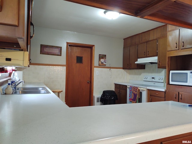 kitchen with sink, white appliances, and tasteful backsplash