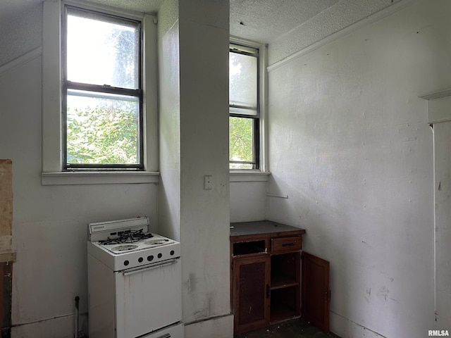 kitchen featuring a textured ceiling and white range with gas stovetop