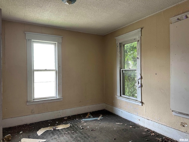 spare room with a textured ceiling and plenty of natural light