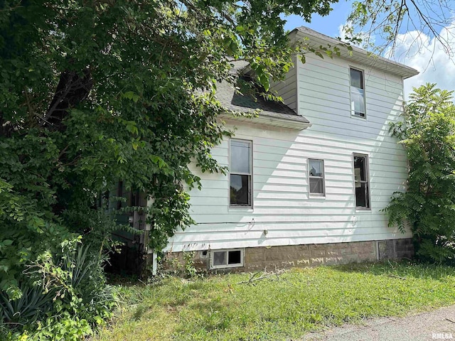 view of side of home with a yard