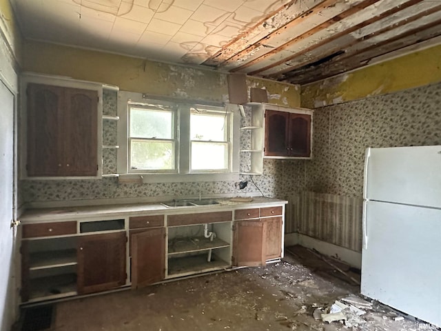 kitchen with sink, white fridge, and dark brown cabinets