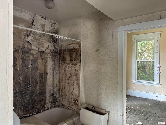 bathroom featuring toilet and tiled shower / bath combo