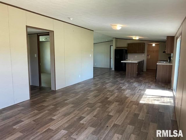 unfurnished living room with dark wood-type flooring and vaulted ceiling