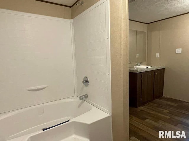 bathroom featuring crown molding, a textured ceiling, shower / tub combination, vanity, and hardwood / wood-style flooring