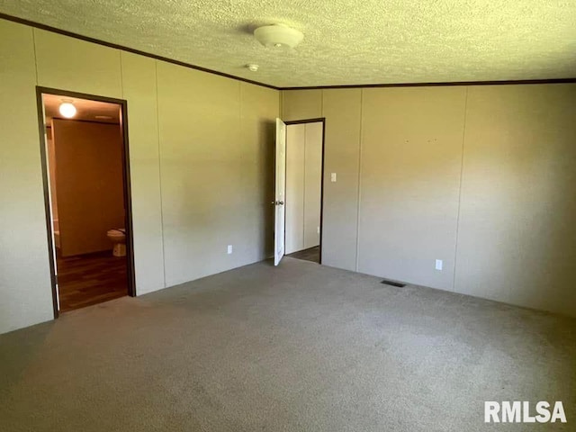 carpeted spare room with a textured ceiling