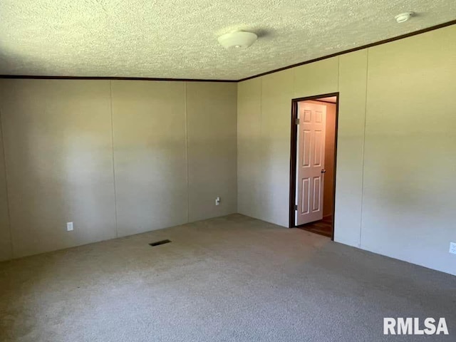 carpeted empty room featuring a textured ceiling